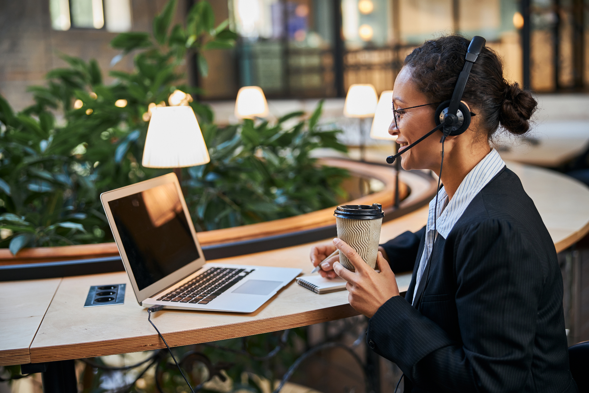 Legal receptionist with headset answering client calls at a laptop